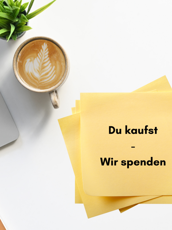 Auf einem weißen Tisch liegen ein Laptop, ein Block, ein Stift, Post Its, ein Kaffee und eine Pflanze. 