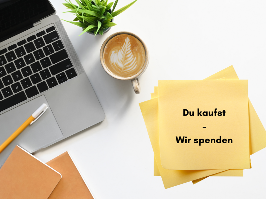 Auf einem weißen Tisch liegen ein Laptop, ein Block, ein Stift, Post Its, ein Kaffee und eine Pflanze. 